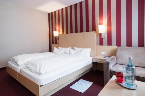 a bedroom with a bed and a couch and a chair at Hotel Deutsches Haus in Bonn