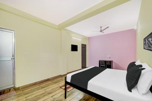 ラーンチーにあるSuper Hotel O HILL VIEW INNの白とピンクの壁のベッドのある寝室