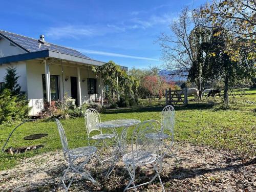 a table and chairs in front of a house with a horse at Cloud Garden Maisonette in Spiez