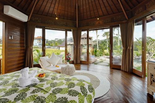 Un dormitorio en una villa con una cama y un sofá. en Wooden Stone Eco Villa, en Ubud