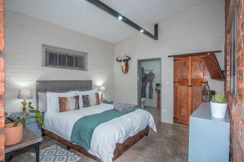 Un dormitorio con una cama grande en una habitación. en Bushbaby Cottage in Hartbeespoort, en Pretoria