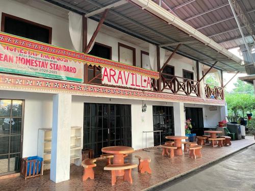 a group of tables and benches outside of a building at Aravilla Homestay Family B in Kota Belud