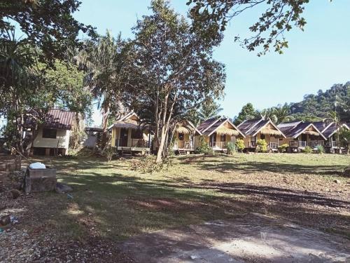 eine Reihe von Häusern auf einem Feld mit Bäumen in der Unterkunft Ingdao Bungalow Koh Chang อิงดาว บังกะโล เกาะช้าง in Ko Chang