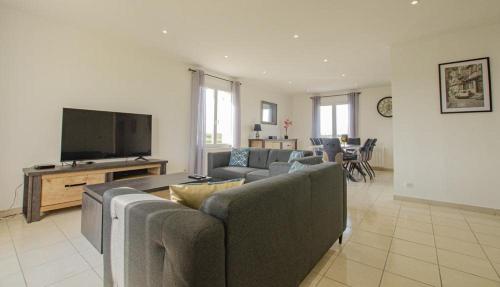 a living room with couches and a flat screen tv at Le paradis de l'orient in Puits-et-Nuisement