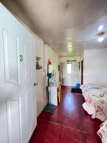 a room with a bed and a table and a door at Aravilla Homestay Triple B in Kota Belud