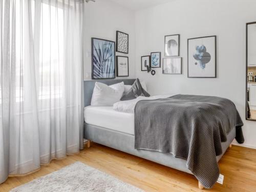 a white bedroom with a bed and a window at My Suite II - Augsburg City - Netflix in Augsburg