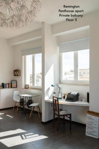 a room with a desk and chairs and windows at Appartamenti di Casa VerbaVolant in Syracuse