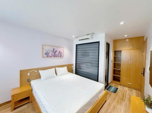 a bedroom with a large white bed in a room at Bay Homestay in Cam Lâm