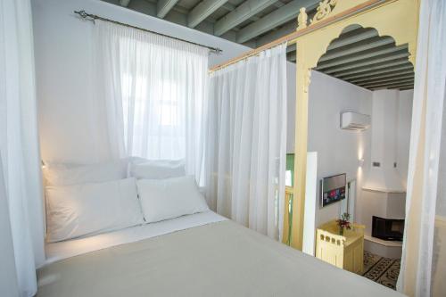 KoskinouにあるMarouli Traditional Villaの白いベッドと窓のある寝室