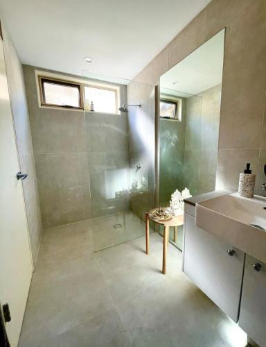 a bathroom with a shower and a sink and a mirror at Beautiful, comfortable 7 mins walk to Mullumbimby in Mullumbimby