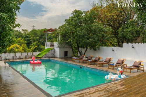 a swimming pool with a red raft in a backyard at EKOSTAY - Amanta Hills 7BHK in Karjat
