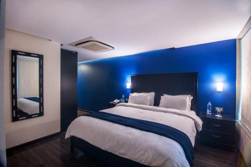a bedroom with blue walls and a large bed at The V Sadan in Mumbai