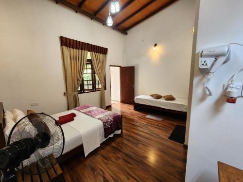 a room with a bed and a fan in it at Poomaz Peace Palace in Ella