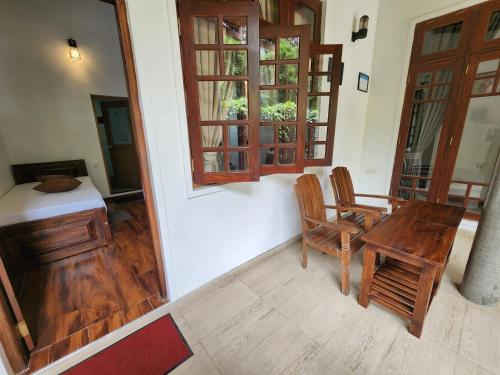 a room with a table and chairs and a window at Poomaz Peace Palace in Ella