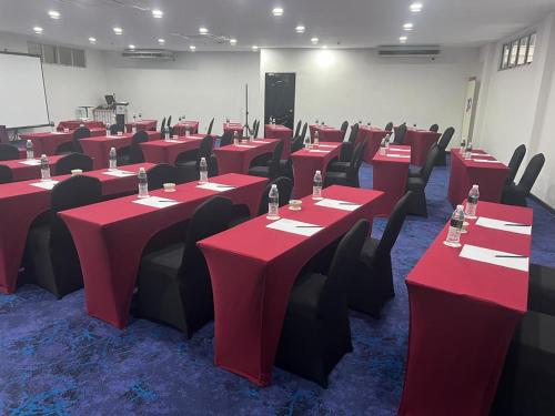 a conference room with red tables and black chairs at Hotel Seri Malaysia Pulau Pinang in Bayan Lepas