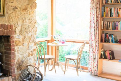 a room with a table and chairs and a window at Adelaide Hills Camellia Cottage Wifi in Crafers