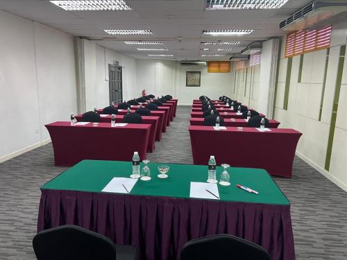 a row of tables in a room with chairs at Hotel Seri Malaysia Pulau Pinang in Bayan Lepas
