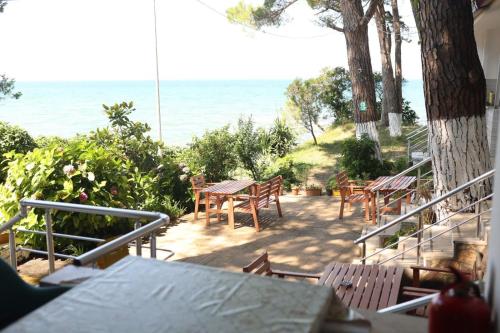 a patio with tables and chairs and the ocean at Sahil Evim Pansiyon in Unye