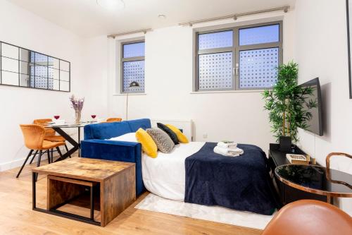 a living room with a blue couch and a table at Modern 2- Bedroom Apartment in Central Redhill! in Redhill