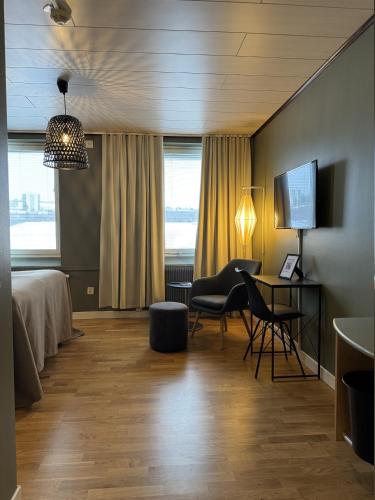 a hotel room with a bed and a desk and chair at Strand City Hotel in Örnsköldsvik