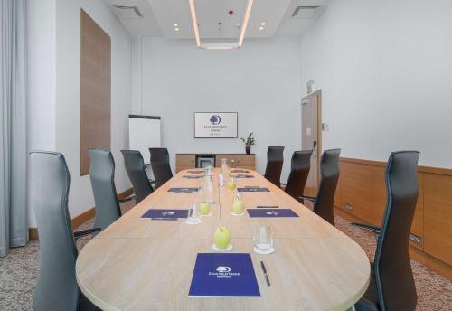 a conference room with a long wooden table and chairs at DoubleTree by Hilton Oradea in Oradea