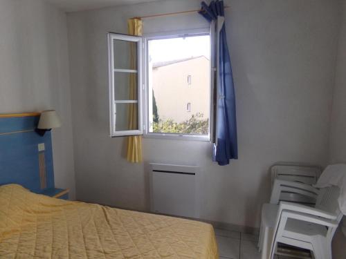 une chambre avec un lit et une fenêtre dans l'établissement Au jardin du golfe, au Plan-de-la-Tour