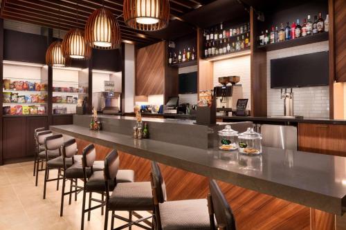 a bar in a restaurant with chairs around it at Hyatt Place Oklahoma City Bricktown in Oklahoma City