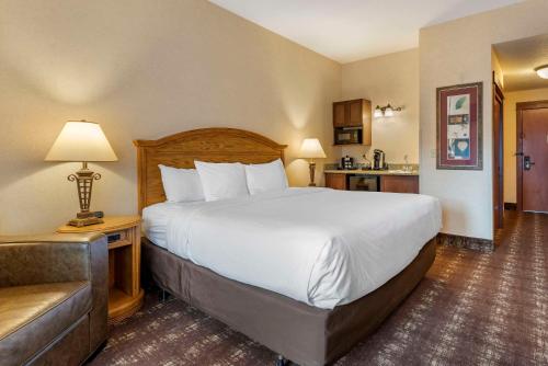a hotel room with a large bed and a couch at Kathryn Riverfront Inn, an Ascend Collection Hotel in Seaside