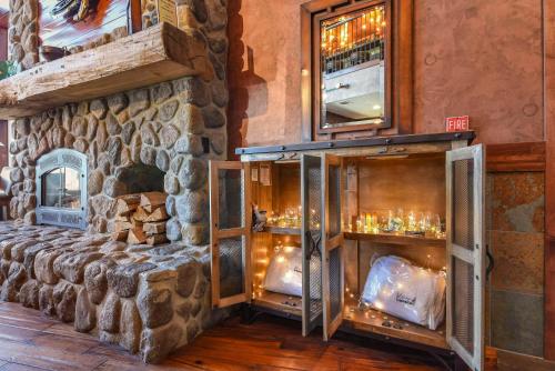 a room with a stone wall with a shelf with glasses at Kathryn Riverfront Inn, an Ascend Collection Hotel in Seaside