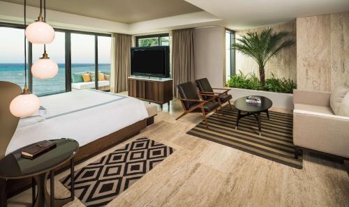 a bedroom with a large bed and a living room at Hyatt Centric Playa del Carmen - Downtown House & Beach House in Playa del Carmen