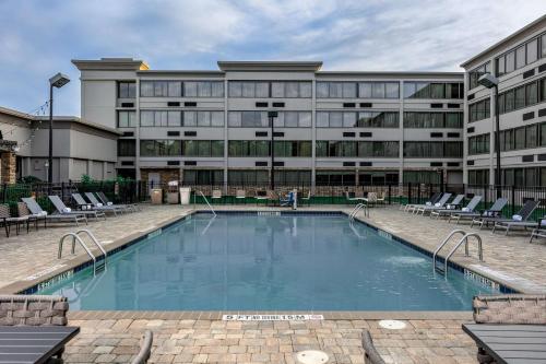 a large building with a swimming pool in front of a building at Doubletree By Hilton Greensboro Airport in Greensboro