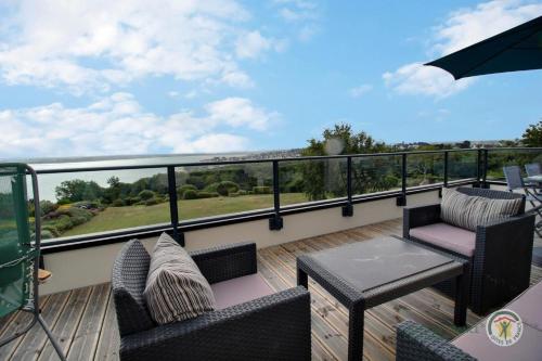 a balcony with two chairs and a table on a deck at Des faudours in Plérin