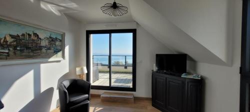 a living room with a window and a black chair at Des faudours in Plérin