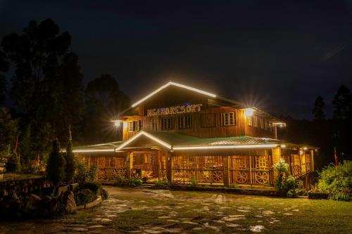 a large house with lights on it at night at Nsaho resort in Fort Portal