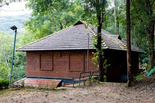 a small brick building with a bench in front of it at Green Garden Jasmin Cottage in Vayittiri