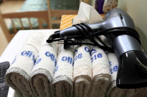 a hair dryer sitting on top of towels on a bed at Guesthouse Ever in Seogwipo