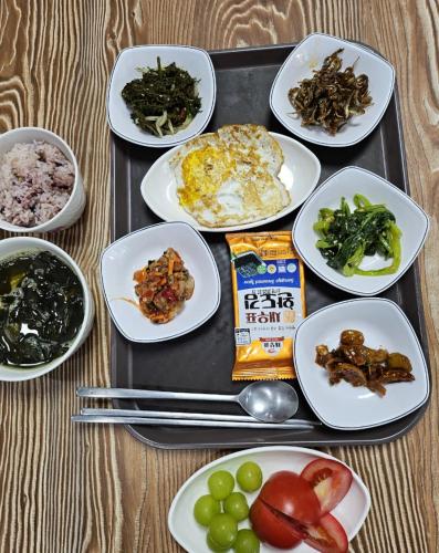 a tray filled with plates of food on a table at Guesthouse Ever in Seogwipo