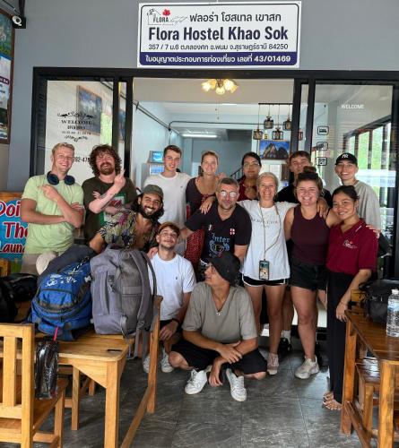 a group of people posing for a picture in a restaurant at Flora Hostel KhaoSok in Khao Sok