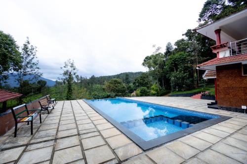 a swimming pool in the middle of a patio with a house at Green Garden Jasmin Cottage in Vayittiri