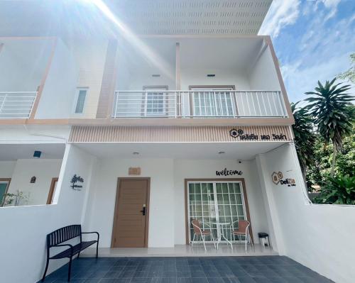 a white house with a balcony and a door at DeliZia de Villa Satun พักได้ 9 ท่าน in Satun