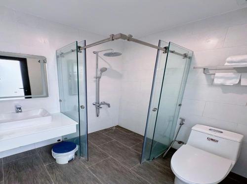 a bathroom with a shower and a toilet and a sink at Bay Homestay in Cam Lâm