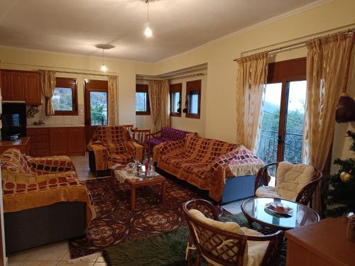 a living room with a couch and chairs and a table at house of nightingale in Konitsa