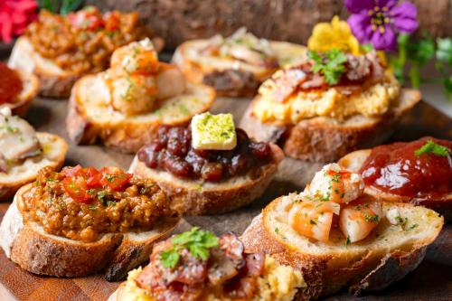 a bunch of bread appetizers with meat and sauce at Hotel O Setouchi ホテルオー瀬戸内 in Kanonji