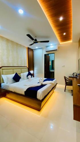 a bedroom with a large bed with a ceiling at Hotel Pravasa Stay, Dewas Naka in Indore