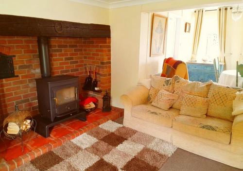 a living room with a couch and a fireplace at Romantic Lakeside Cottage by the Beach! with Super Cosy Log Burner! The Perfect Escape to Your Home from Home by the Sea! So Relaxing - You Won't want to Leave! Pet Friendly! in Mablethorpe