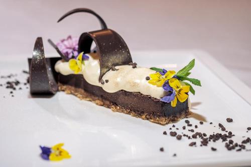 a chocolate dessert with flowers on a white plate at Relais La Corte dei Papi in Cortona