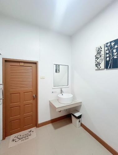 a bathroom with a sink and a brown door at DeliZia de Budget พักได้ 2 ท่าน in Satun