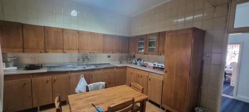 サルトにあるNights of the Orient Guesthouseのキッチン(木製キャビネット、木製テーブル付)