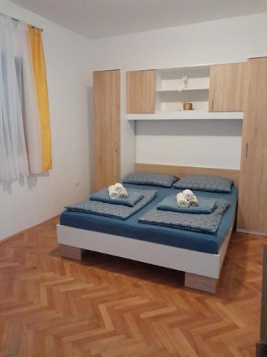 a bedroom with a bed with two pillows on it at Apartman Larus in Starigrad-Paklenica
