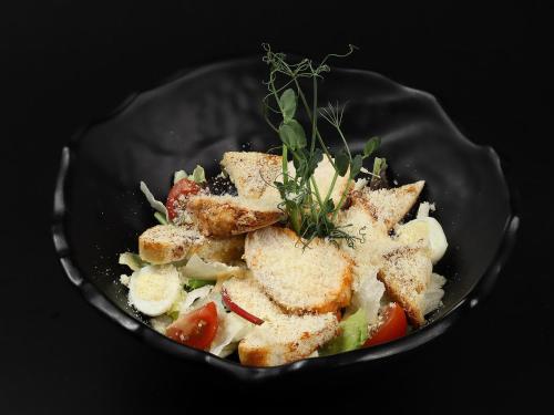 a plate of food with a salad with meat and vegetables at Hotel Podgorie Spa in Bukovel